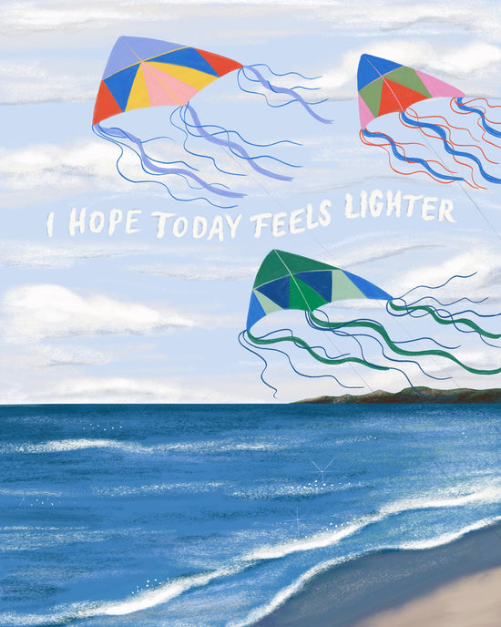 An art print depicting a beach scene with three colorful jelly-like kites flying in a light blue sky with white clouds. The text 'I HOPE TODAY FEELS LIGHTER' is written across the center.
